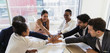 © Tom Merton/Caia Image - Business people joining hands in conference room meeting