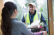 © Chris Ryan/Caia Image - Woman greeting food deliveryman at front door