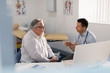 © Tom Merton/Caia Image - Male doctor talking with patient in doctors office