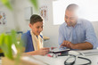 © Tom Merton/Caia Image - Male pediatrician showing digital tablet to boy patient in doctors office