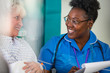 © Chris Ryan/Caia Image - Friendly female nurse talking with senior patient in hospital