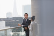 © Tom Merton/Caia Image - Business people talking and drinking coffee on sunny, urban balcony