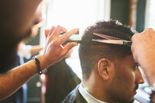 Male Barber Giving Customer A Haircut In Barbershop