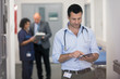 © Sam Edwards/Caia Image - Male doctor using digital tablet in hospital corridor