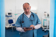 © Sam Edwards/Caia Image - Portrait confident, serious male doctor using digital tablet in hospital room