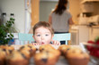 © Jarusha Brown/Caia Image - Cute excited girl starting at fresh homemade muffins