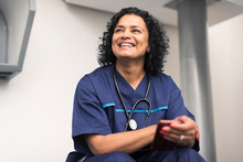 Portrait Smiling, Happy Female Doctor Using Smart Phone