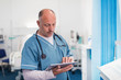 © Sam Edwards/Caia Image - Male doctor using digital tablet in hospital room