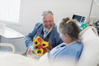 © Sam Edwards/Caia Image - Happy senior man with flower bouquet visiting wife in hospital