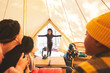 © Trevor Adeline/Caia Image - Family watching happy girl enter camping yurt