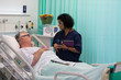 © Tom Merton/Caia Image - Doctor with digital tablet making rounds, talking with senior patient in hospital room