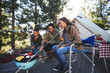 © Trevor Adeline/Caia Image - Family cooking vegetables at campsite grill