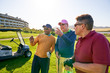 Male golfer friends talking on sunny golf course