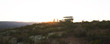 © Trevor Adeline/Caia Image - Safari tour group and off-road vehicle on hill at sunrise South Africa