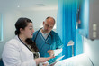 © Sam Edwards/Caia Image - Doctors using digital tablet in hospital room