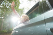 © Himalayan Pics/Caia Image - Carefree girl with arm out sunny car window