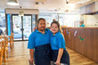 © Trevor Adeline/Caia Image - Portrait confident young women with Down Syndrome working in cafe