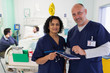 © Tom Merton/Caia Image - Portrait confident doctors with digital tablet making rounds in hospital room