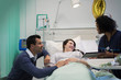 © Tom Merton/Caia Image - Doctor with digital tablet making rounds, talking with couple in hospital room