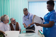© Tom Merton/Caia Image - Doctor and nurse with digital tablet and medical chart making rounds, talking with senior couple in hospital room