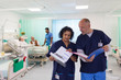 © Tom Merton/Caia Image - Doctors with medical charts making rounds, consulting in hospital ward