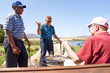 © Trevor Adeline/Caia Image - Happy male golfers talking and drinking beer at clubhouse patio
