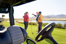 Male Friends Talking Outside Golf Cart On Sunny Golf Course