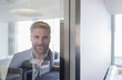 © Martin Barraud/Caia Image - Portrait confident businessman at window in conference room