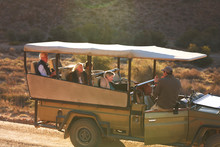 Safari Tour Guide And Group In Off-road Vehicle