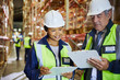 © Ryan Lees/Caia Image - Manager and worker with clipboards meeting in distribution warehouse