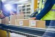 © Ryan Lees/Caia Image - Workers scanning and processing boxes on conveyor belt in distribution warehouse