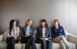 © Martin Barraud/Caia Image - Smiling businesswomen talking in a row on sofa