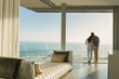 © Tom Merton/Caia Image - Affectionate couple hugging on sunny luxury balcony with ocean view