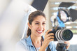 © Chris Ryan/Caia Image - Smiling female photographer behind camera in studio