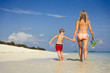 © Paul Bradbury/Caia Image - Mother and son walking on sunny tropical beach