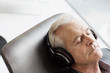 © Martin Barraud/Caia Image - Senior man with headphones listening to music and reclining