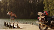 © Paul Bradbury/Caia Image - Young man carrying young woman on lakeside dock near motorcycle
