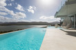 © Martin Barraud/Caia Image - Sunny tranquil modern luxury home showcase exterior patio with infinity pool and ocean view