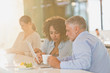 © Tom Merton/Caia Image - Business people drinking coffee and using digital tablet