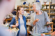© Sam Edwards/Caia Image - Smiling pregnant woman and mother shopping in shop
