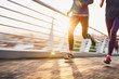 © Ryan Lees/Caia Image - Runner couple running on sunny urban footbridge at sunrise