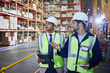 © Ryan Lees/Caia Image - Manger and worker with clipboard and digital tablet talking in distribution warehouse