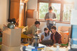 © Justin Pumfrey/Caia Image - Young couples roommates using laptop surrounded by moving boxes