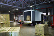 © Ryan Lees/Caia Image - Trucks and cardboard box pallets at distribution warehouse loading dock