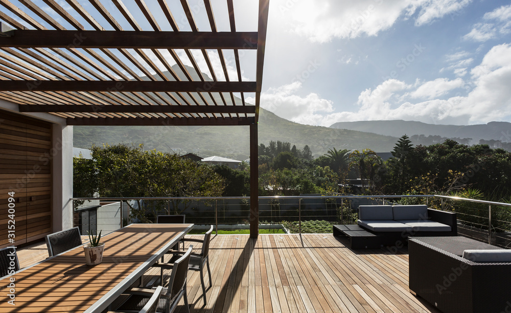 Sunny modern luxury home showcase exterior with wooden deck and ...