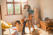 © Justin Pumfrey/Caia Image - Mother and daughter hugging unpacking boxes in apartment