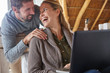 © Ryan Lees/Caia Image - Happy couple laughing and using laptop