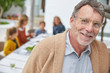 © Ryan Lees/Caia Image - Portrait smiling senior man enjoying patio lunch with family
