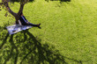 © Martin Barraud/Caia Image - Serene businessman relaxing on blanket below tree in sunny park