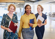 © Ryan Lees/Caia Image - Smiling businesswomen walking in office
